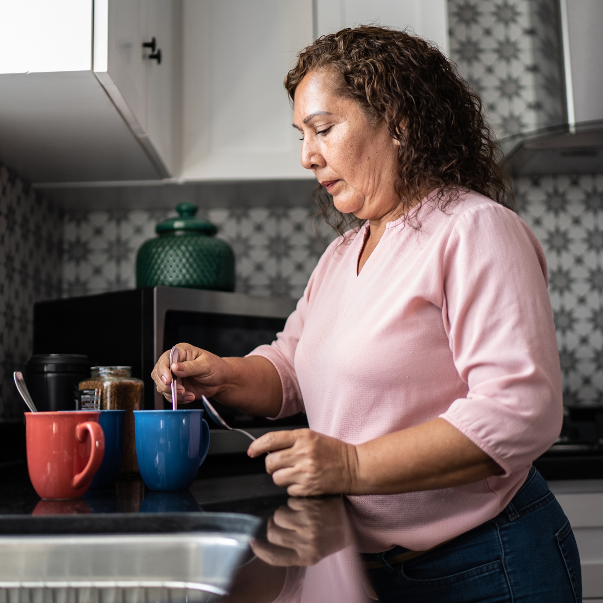 A woman makes tea in the kitchen