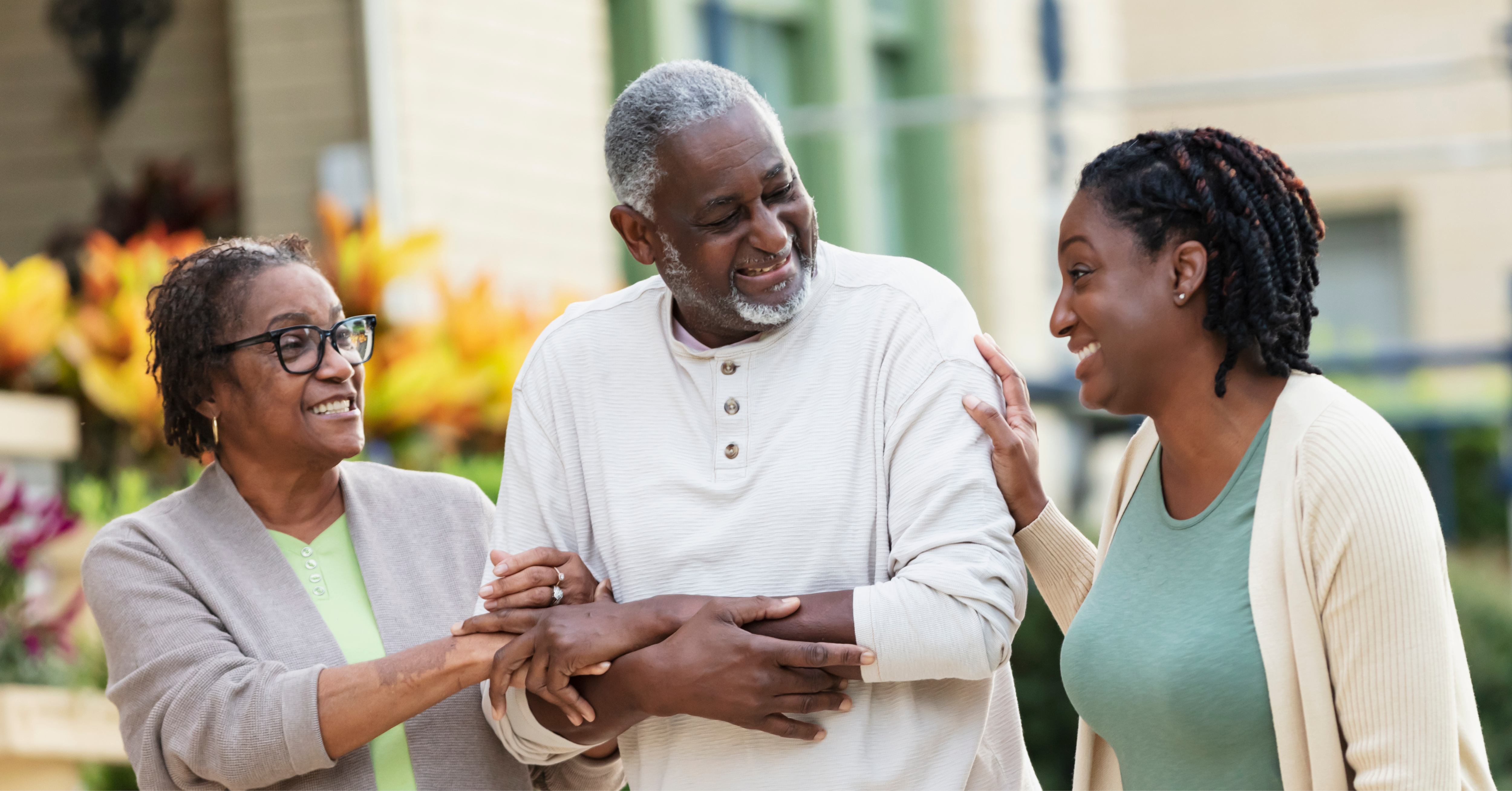 Three people linking arms and smiling