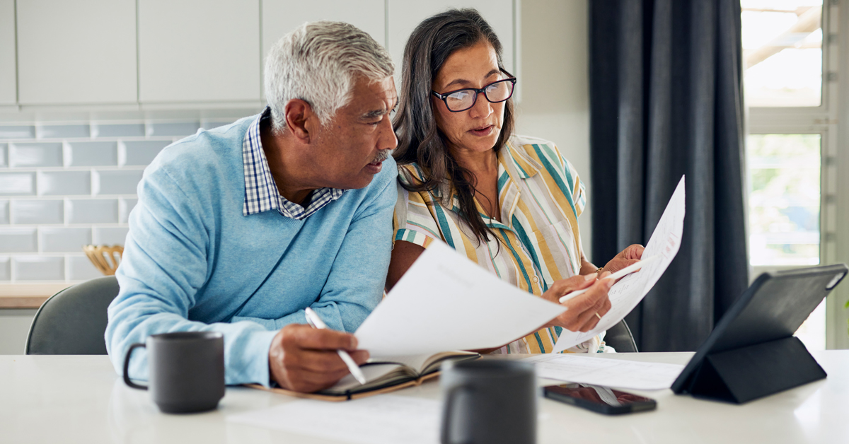 Couple sitting at their kitchen counter reviewing documents