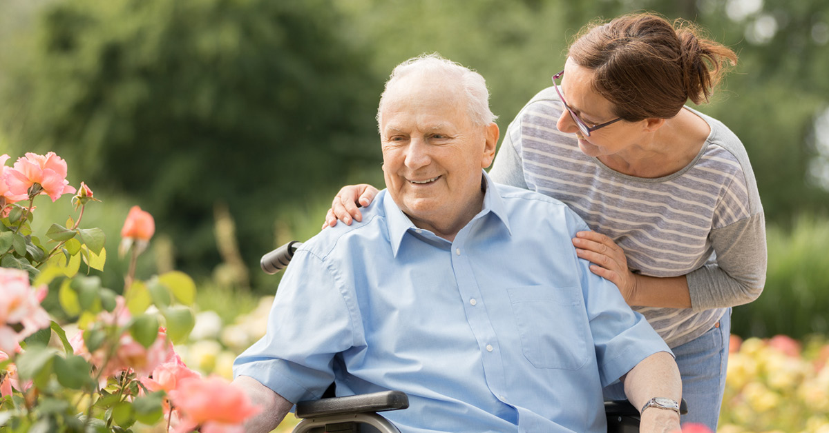 Professional landscape portrait of a woman and man; in a therapy setting, a client smiles while receiving a vaccination.