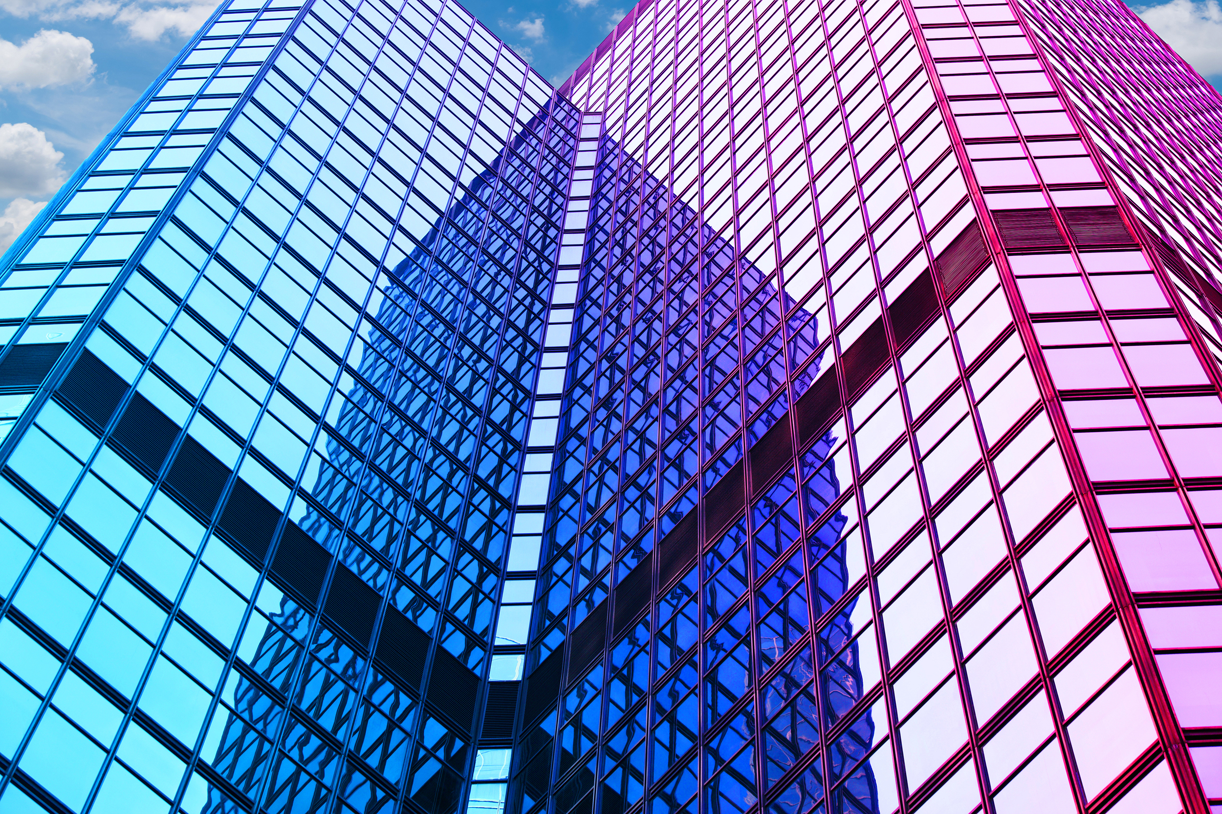 Intersecting glass skyscrapers with blue and pink reflective windows