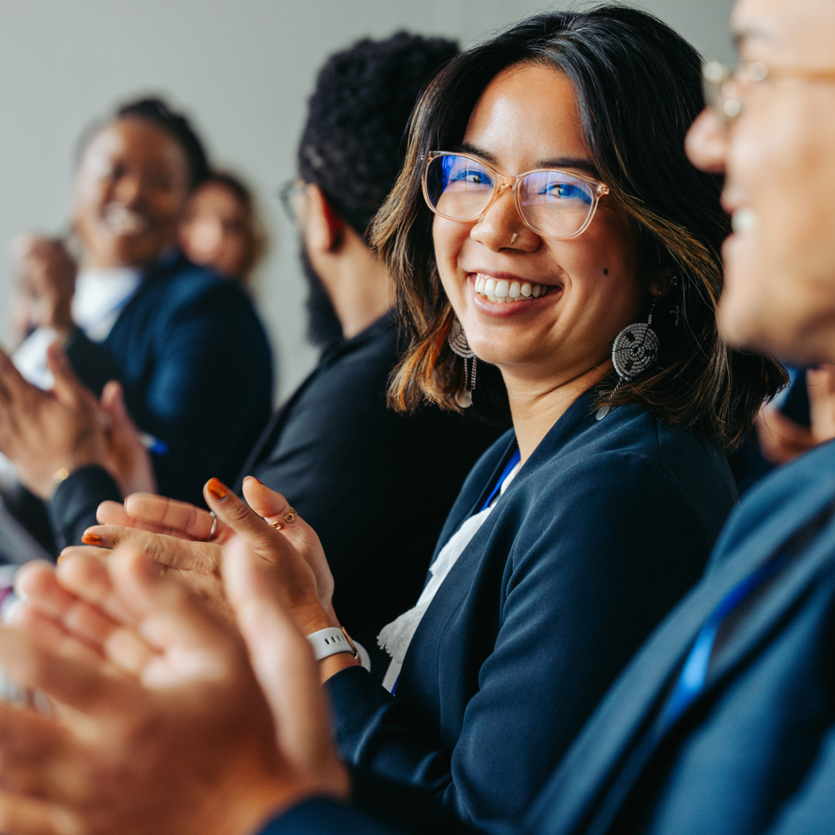 A dynamic group of business professionals, encompassing both genders, collaboratively engaging in work activities.