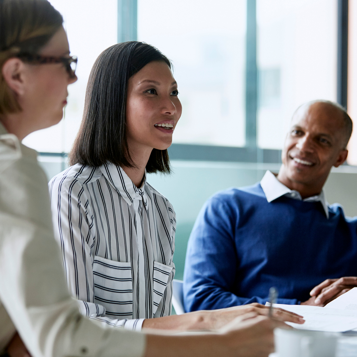 A cheerful young female executive actively cooperating with her male counterpart in a corporate office setting.