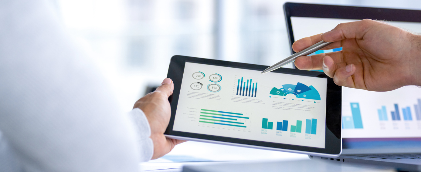 A professional shows data and graphs on a tablet in a business setting.
