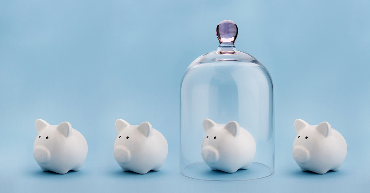 Four piggy banks with one under a glass cover