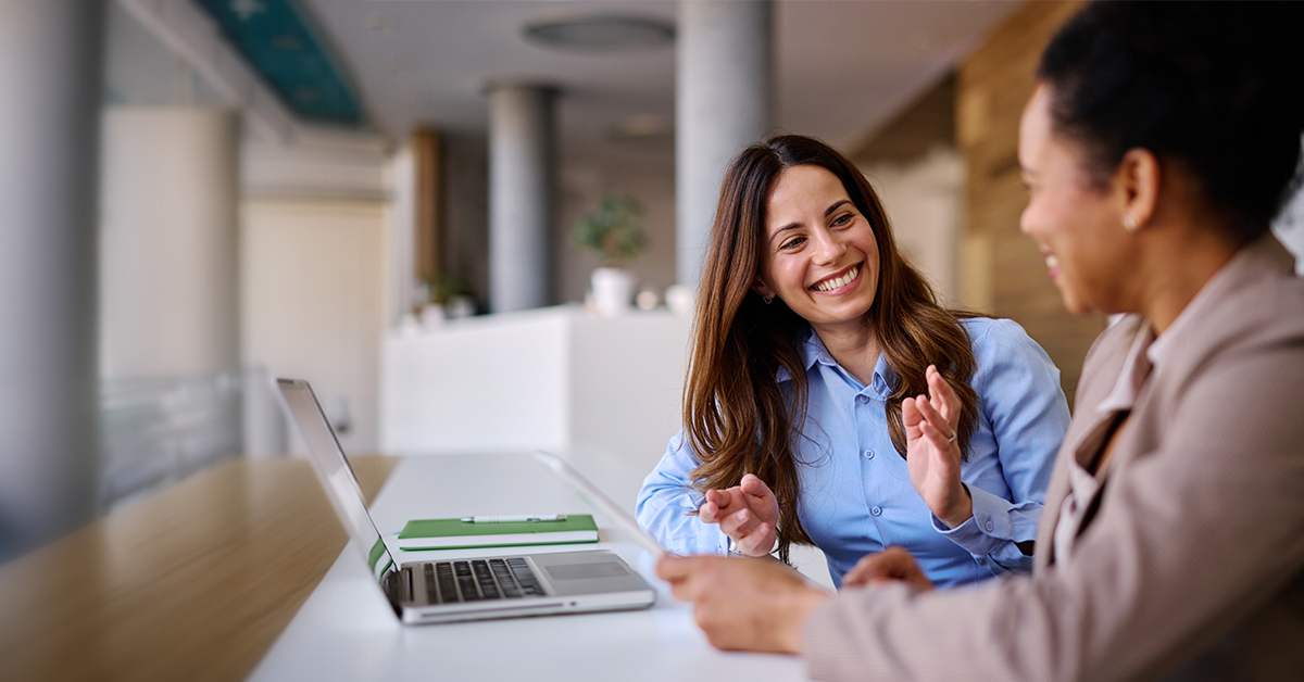 Smiling young professional woman in business attire, projecting confidence and positivity in a corporate environment.