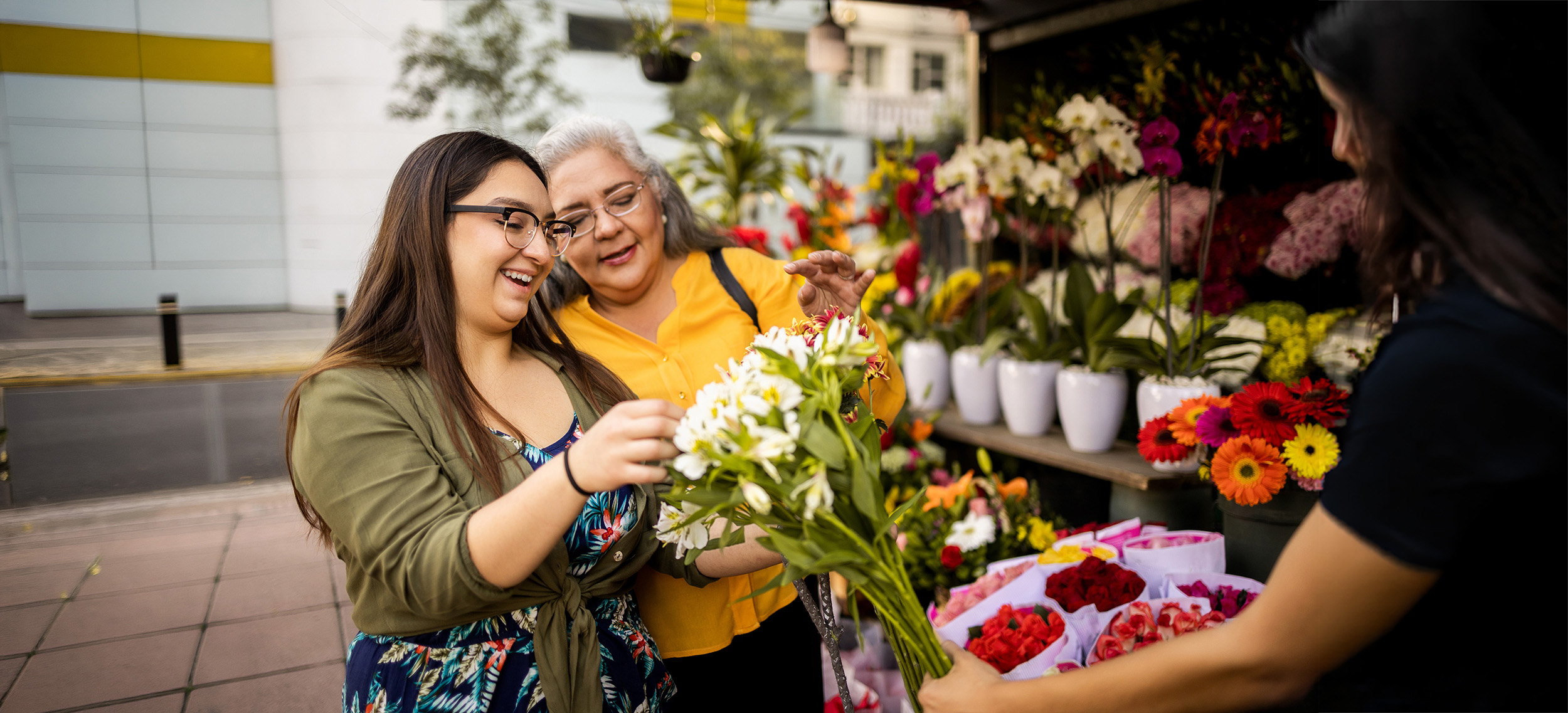 Two women picking our flowers from a street vendor.