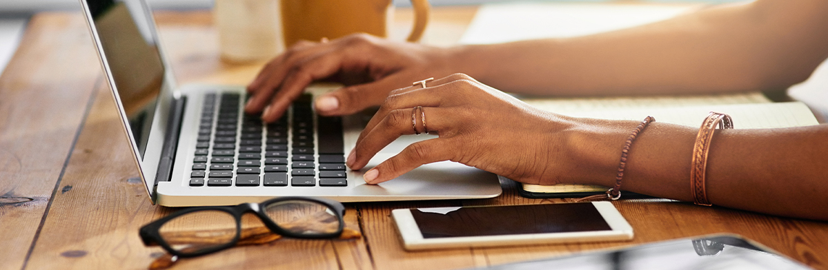 Hands typing on a laptop keyboard, showcasing the integration of technology in professional business tasks and communication.